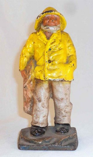 Antique Heavy Cast Iron Doorstop Fisherman Or Old Salt In Yellow Jacket And Hat