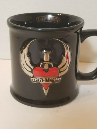 2002 Harley Davidson Black Coffee Mug With Silver Wings And Dagger Heart Logo.