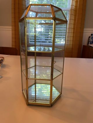 Small Glass Display Case With Glass Shelves And Mirror On Bottom Shelf.