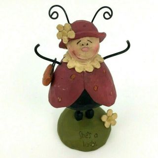 B.  Lloyd Ladybug With A Purse Spring Figurine