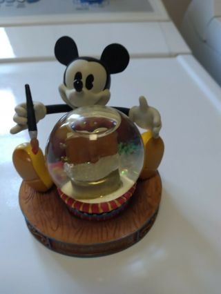 Mickey Mouse Holding Snow Globe With Paint Brush And Book