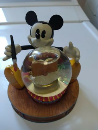 mickey mouse holding snow globe with paint brush and book 2