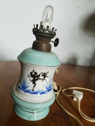 Antique Oil Lamp.  The Devil Kicking Cupid