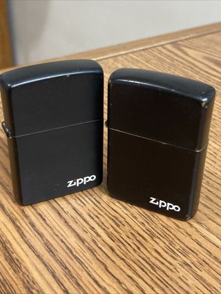 Two Vintage Black Zippo Lighters With White Zippo Logo And Red Flame