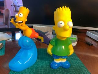 The Simpsons: 2 Plastic Bart Containers,  One Is A Bank (standing) The Other A Co