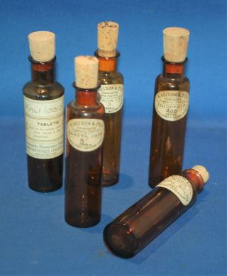 A set of five amber glass apothecary bottles,  paper labels,  cork stoprs 2